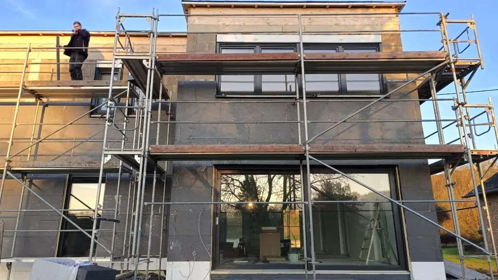 Neubau mit Gerüst, große Fensterelemente bereits eingebaut