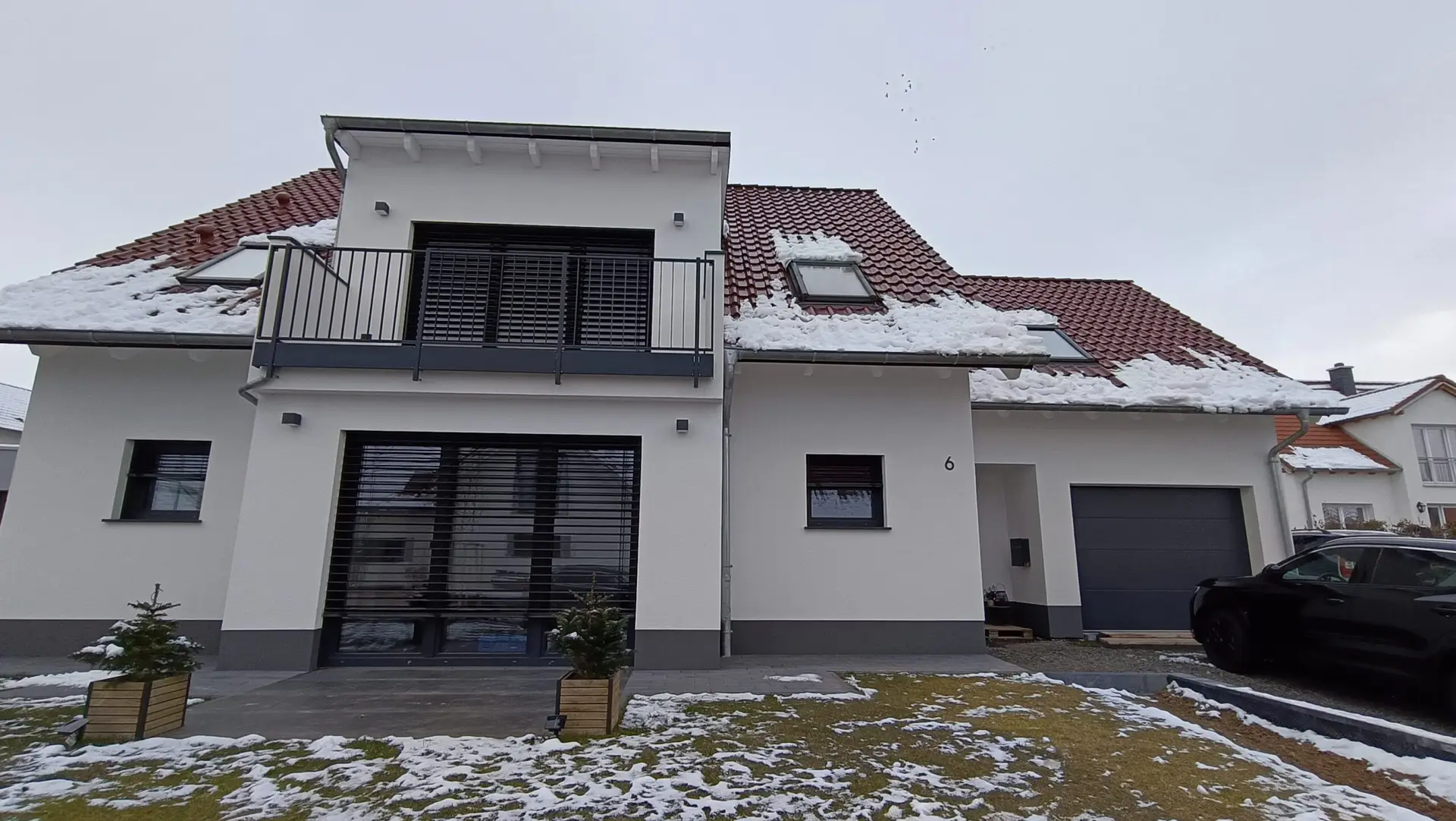 Fertiggestelltes Einfamilienhaus mit dunklen Fenstern, Raffstore und Dachfenster