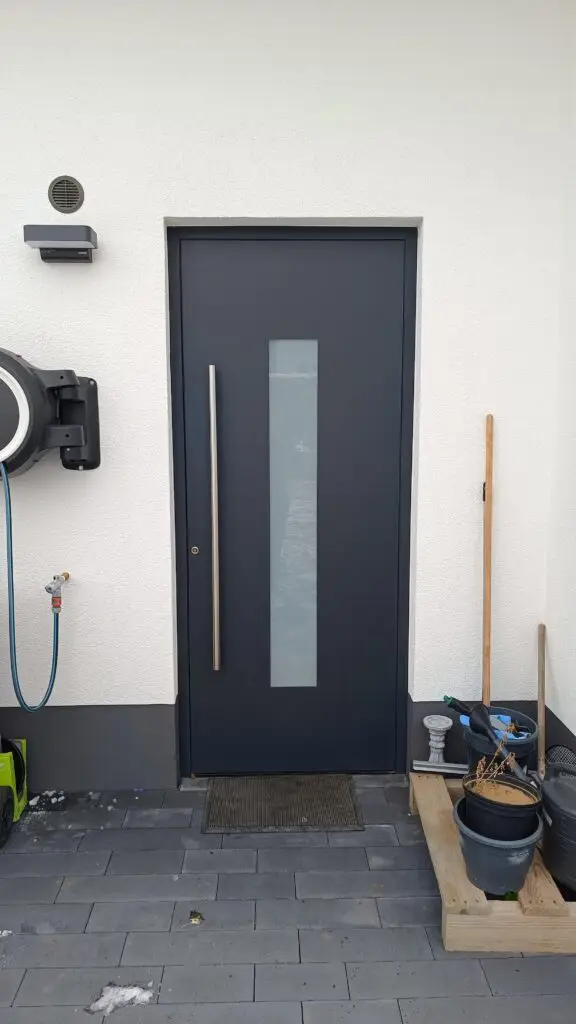 Anthrazitfarbene Haustür mit Lichtausschnitt, Klingel und Kamera