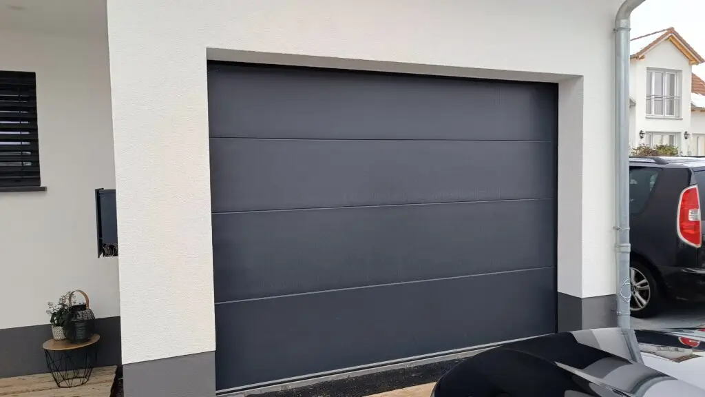 Anthrazitfarbenes Sektionaltor an einer Garage