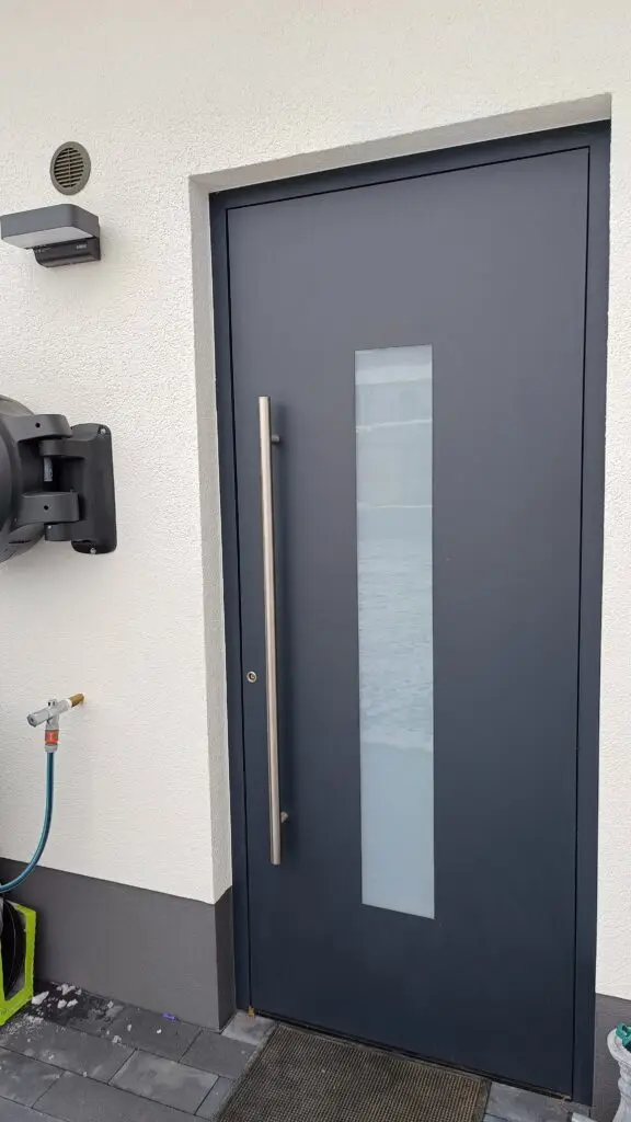 Anthrazitfarbene Haustür mit Lichtausschnitt und Griffstange