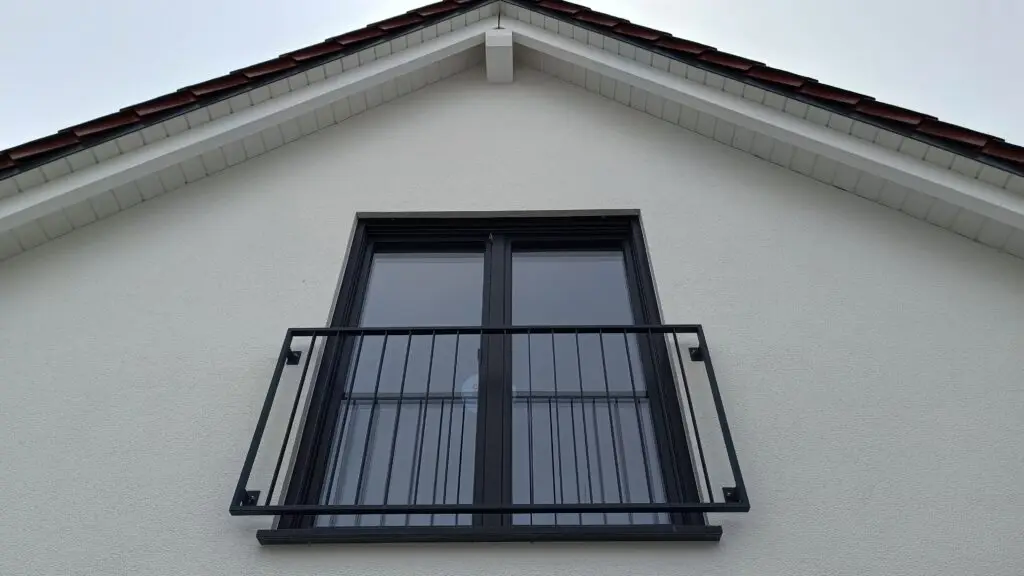 Zwei dunkle Giebelfenster mit französischem Balkon