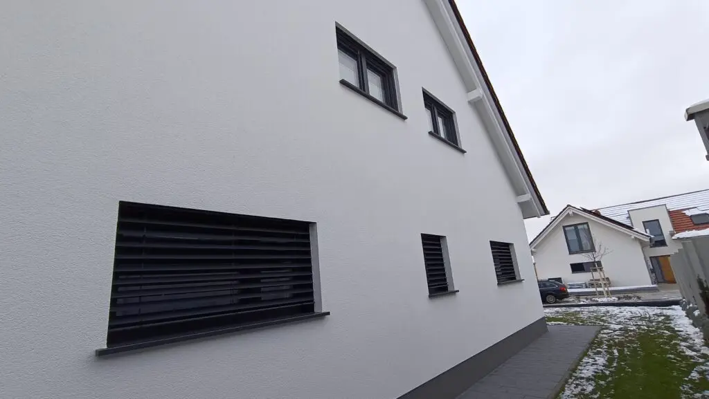 Raffstore außen vor einem Fenster am Giebel