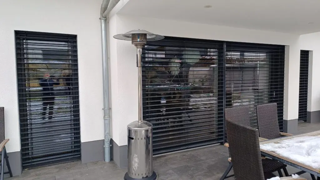 Raffstore an Terrassentür und Fenstern, unterschiedlich weit heruntergefahren