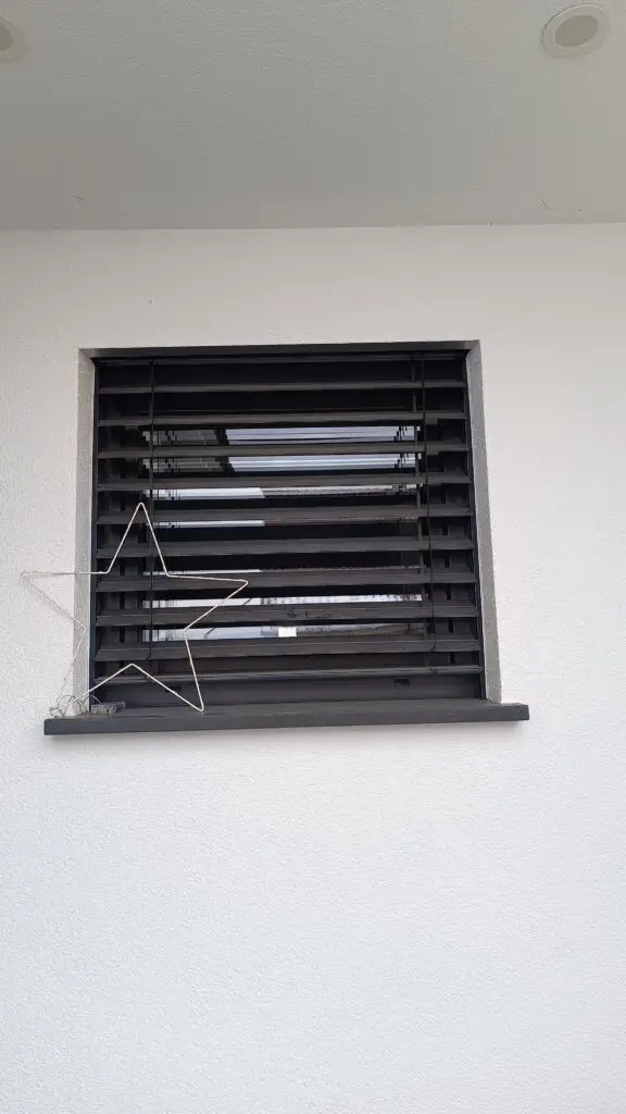 Fenster mit halb heruntergefahrenem Raffstore