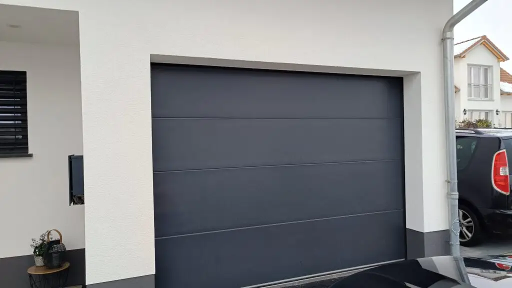 Anthrazitfarbenes Sektionaltor an einer Garageneinfahrt