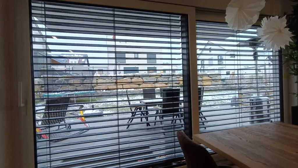 Innenraum mit gedrehten Raffstore-Lamellen und Blick nach draußen